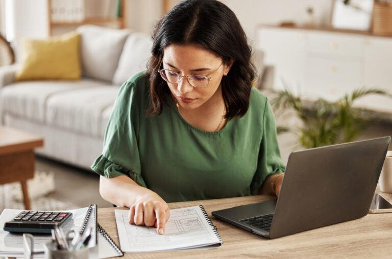 Woman reviewing bills with a calculator