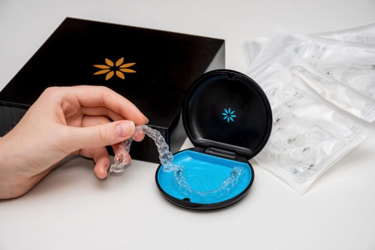 Hand lifting a clear aligner out of its case